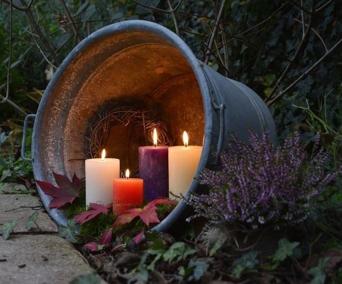 lit candles in a galvanized bucket