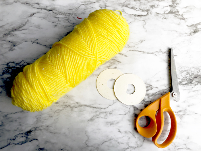 yarn, cardboard pom templates, and scissors