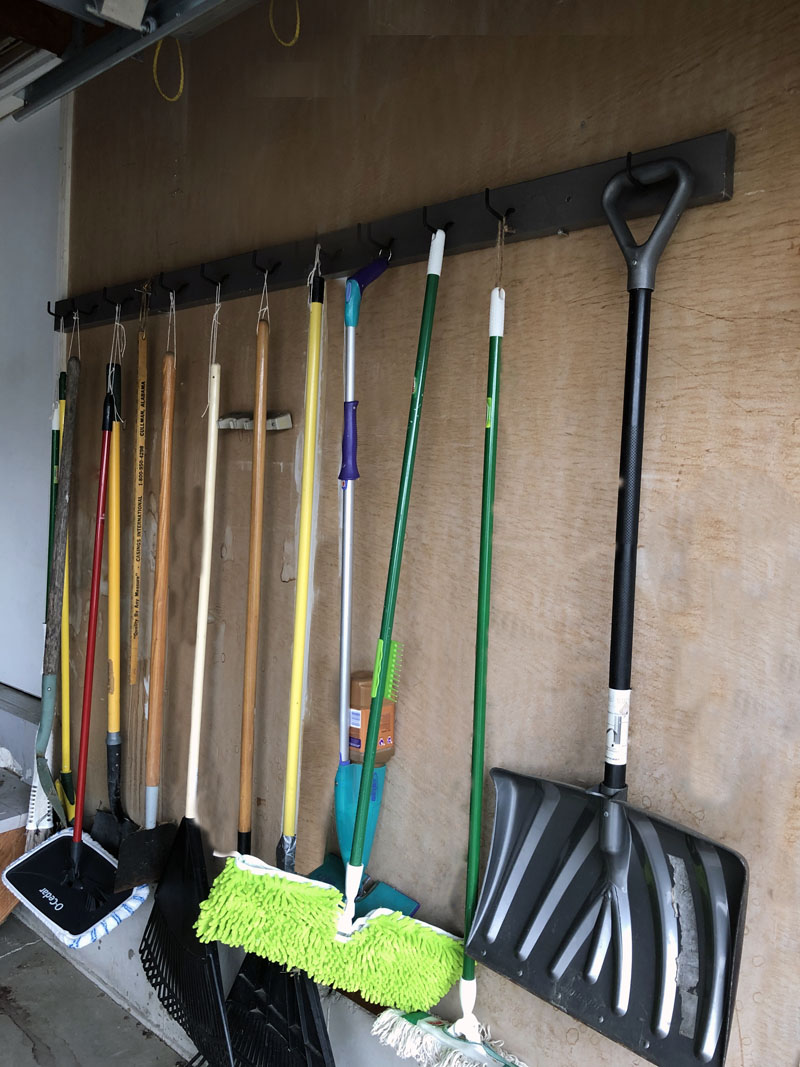 13 tools hanging on a DIY garage tool rack